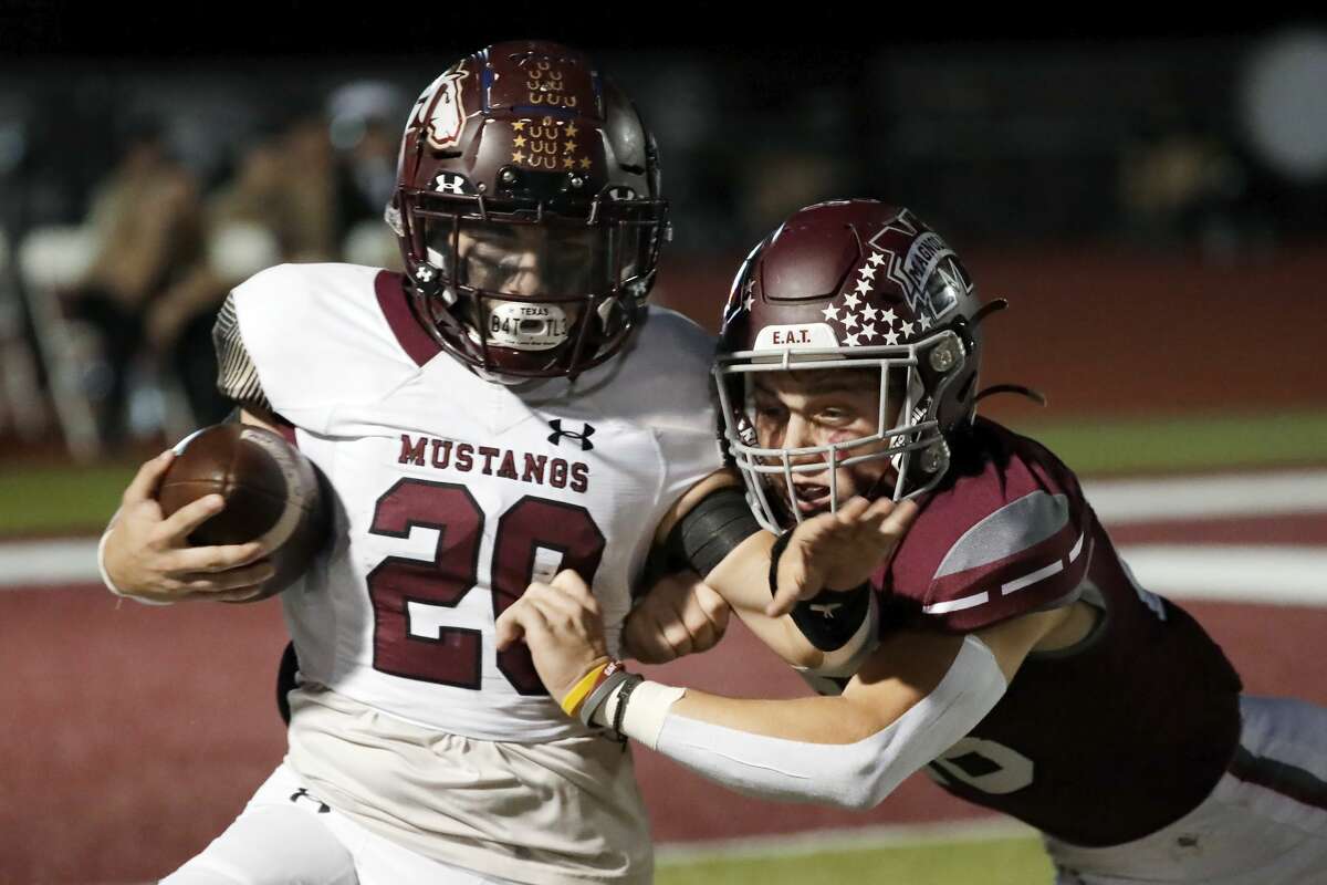 Magnolia West's Hunter Bilbo, left, pushes off the tackle attempt by Magnolia defender John Alexander during the first half of their District 8 5A, D1 high school football game at Bulldog Stadium Friday, Oct. 15, 2021 in Magnolia, TX.