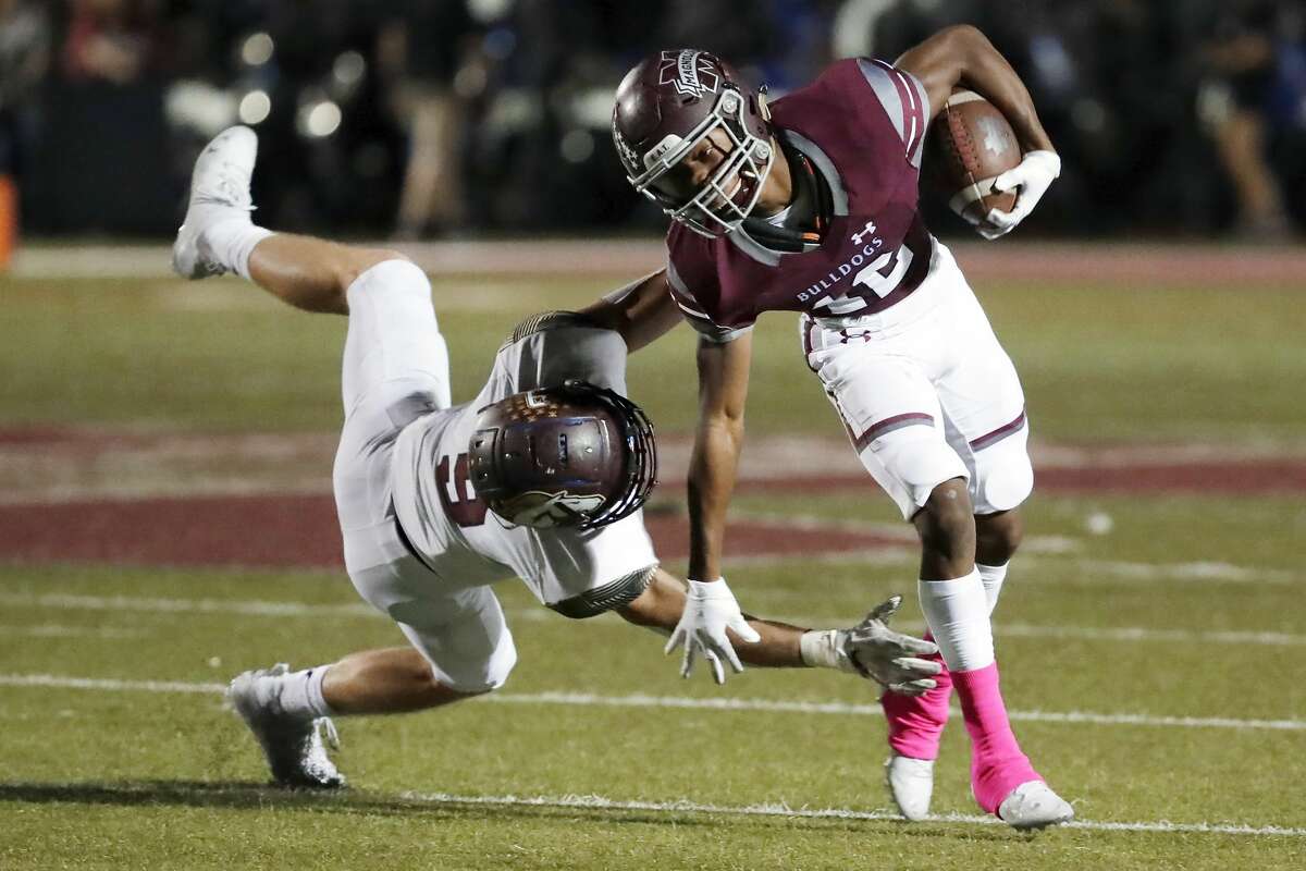 Magnolia West's Jackson Blank, left, misses the tackle on Magnolia running back Deonald Butler, right during the first half of their District 8 5A, D1 high school football game at Bulldog Stadium Friday, Oct. 15, 2021 in Magnolia, TX.