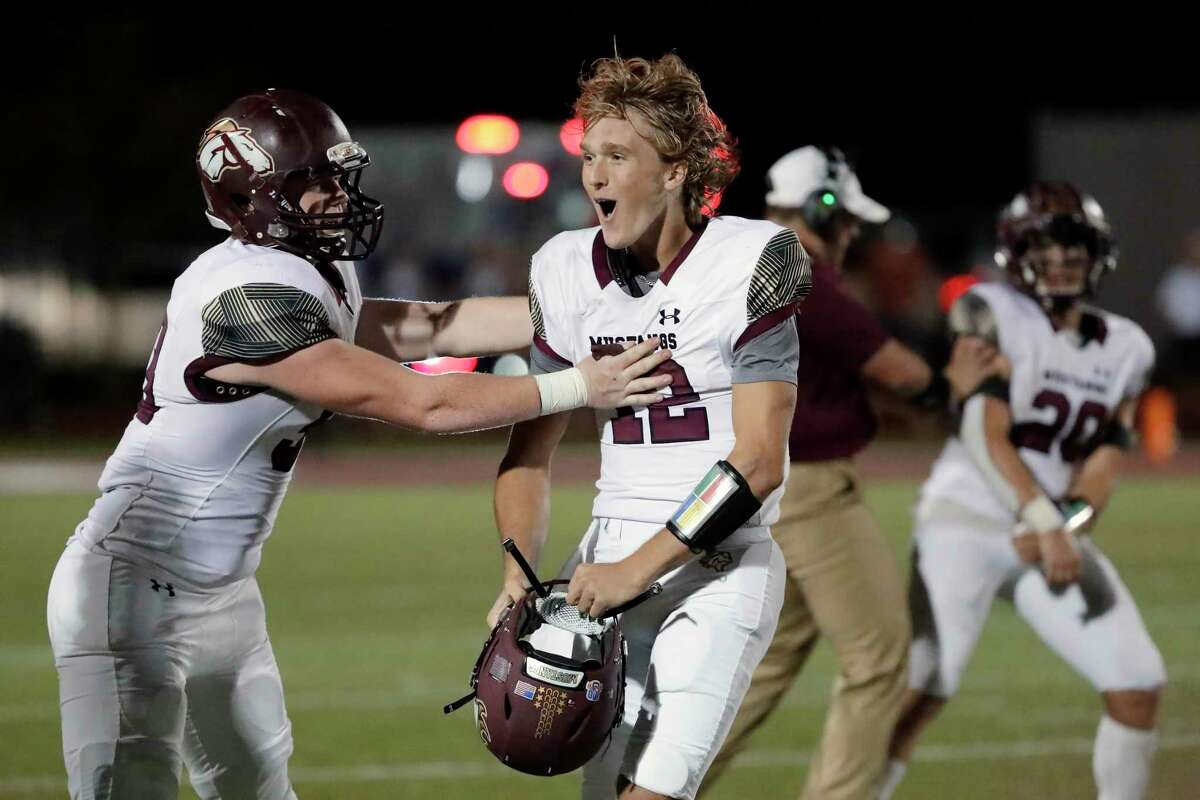 Magnolia West’s Jonathan Hietikko, left, and Brock Dalton, center, celebrate their 21-14 win over Magnolia in their District 8 5A, D1 high school football game at Bulldog Stadium Friday, Oct. 15, 2021 in Magnolia, TX.