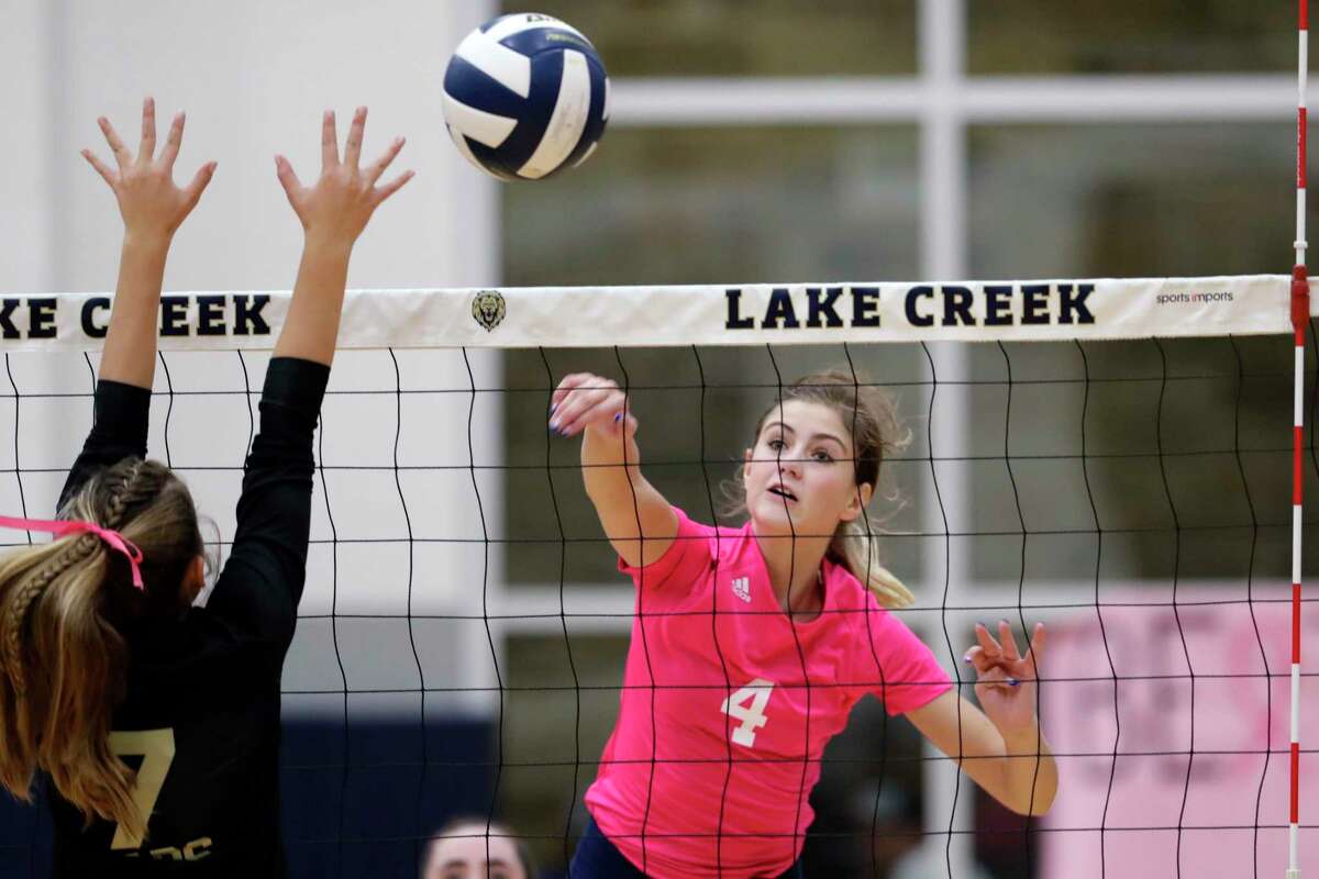 Lake Creek’s Payton Woods (4) spikes the ball past Montgomery’s Lauren Williams (7) during their regular season District 20-5A volleyball match at Lake Creek High School Tuesday, Oct. 12, 2021 in Houston, TX.