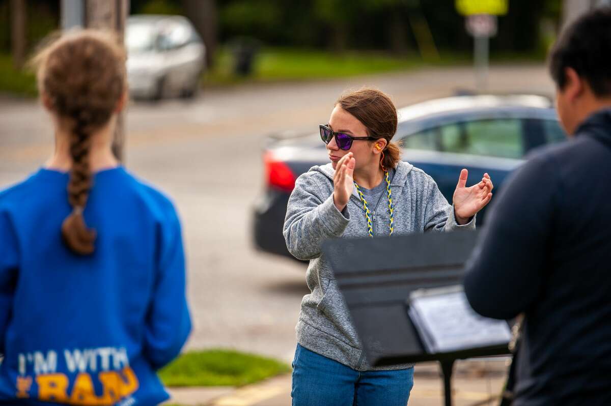 Maddie Bartlett, 17, of Midland High School conducts the Midland High band on Oct. 16, 2021 in the LaLonde's Market parking lot.