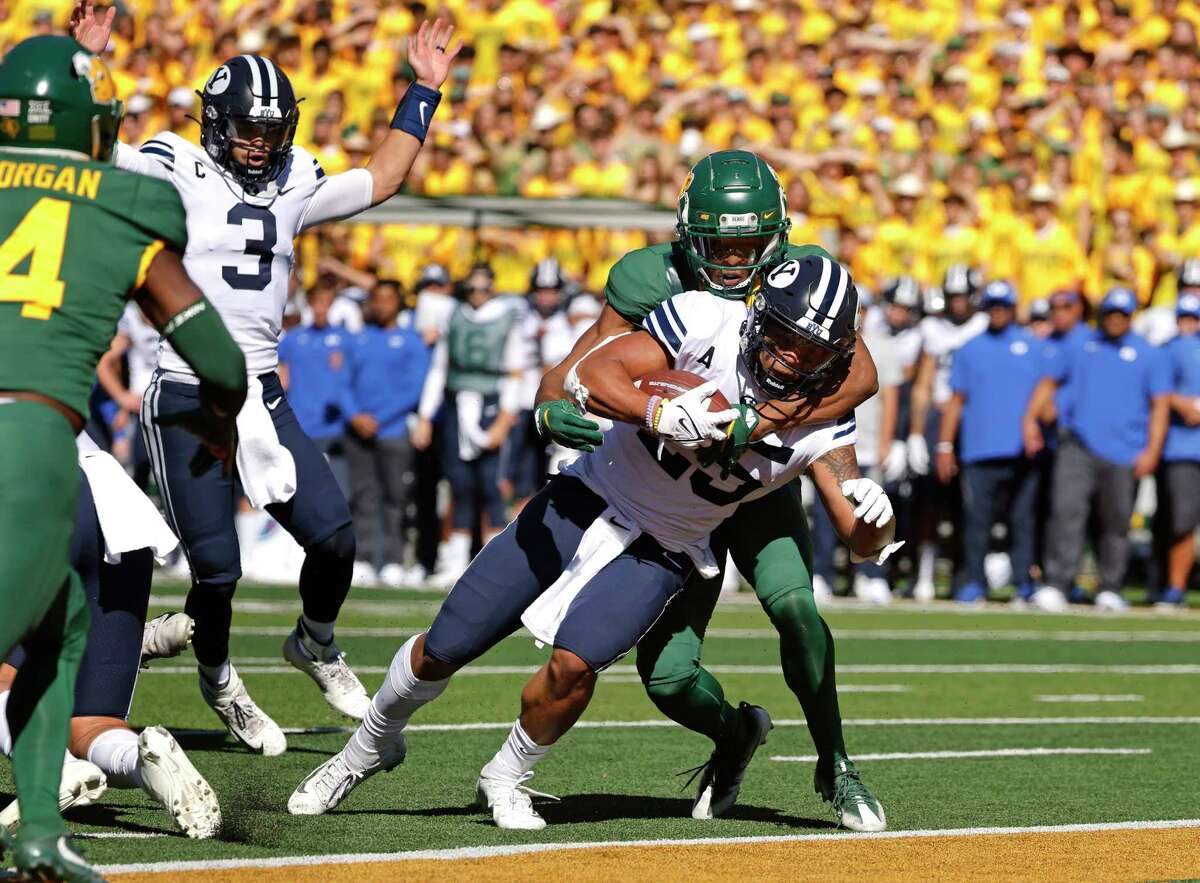 BYU quarterback Jaren Hall (3) celebrates as teammate and running back Tyler Allgeier (25) crosses the goal line to score a touchdown as Baylor safety JT Woods (22) defends during the first half of an NCAA college football game, Saturday, Oct. 16, 2021, in Waco, Texas.