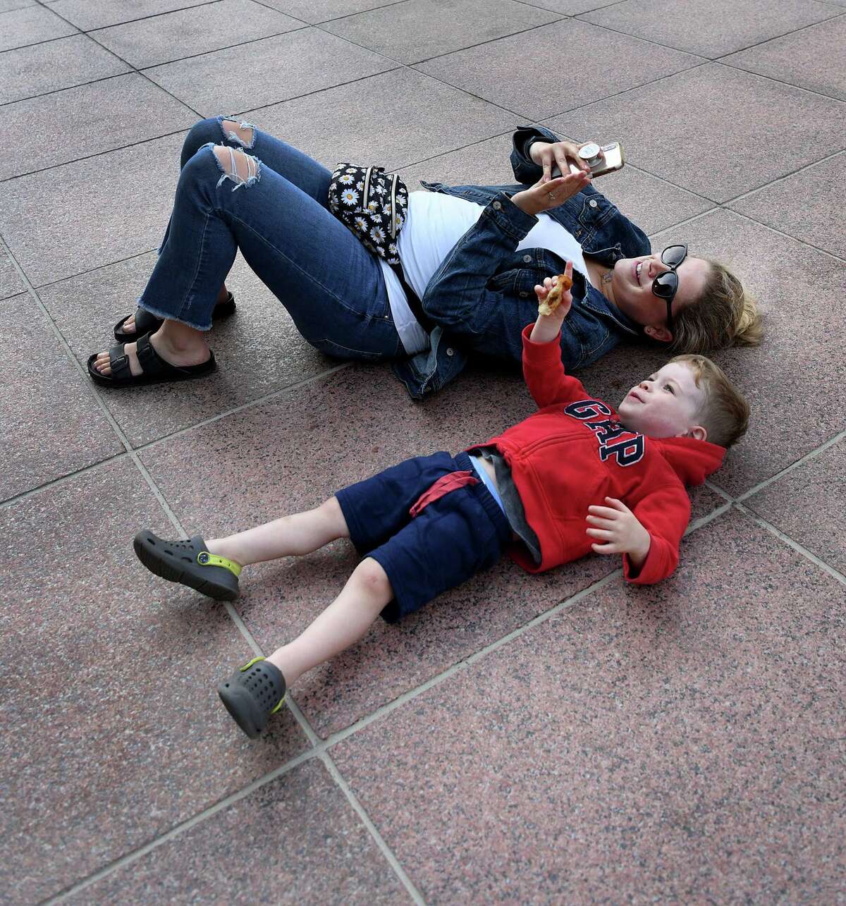 Sarah Webster and her son, Nolan, 2 1/2, watch husband and father, Jeff Webster, rappel from the top of the People’s United Bank building.