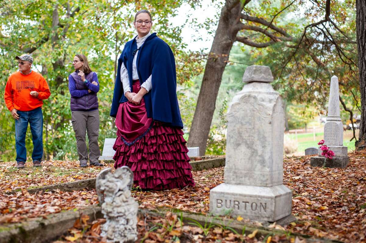 Edenville resident Jennifer Page plays Emeline Burton, a mother of a Civil War veteran, during the Edenville Civil War Veterans Cemetery Walk on Oct. 16, 2021 at the Old Edenville Cemetery. She is looking at the grave of Burton.