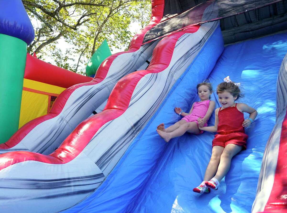 Julia Doerflinger, 5, left, and her cousin, Kambree Doerflinger, 6, play on an inflatable slide during the during the Montgomery Fall Festival in historic downtown Saturday, Oct. 16, 2021 in Montgomery.