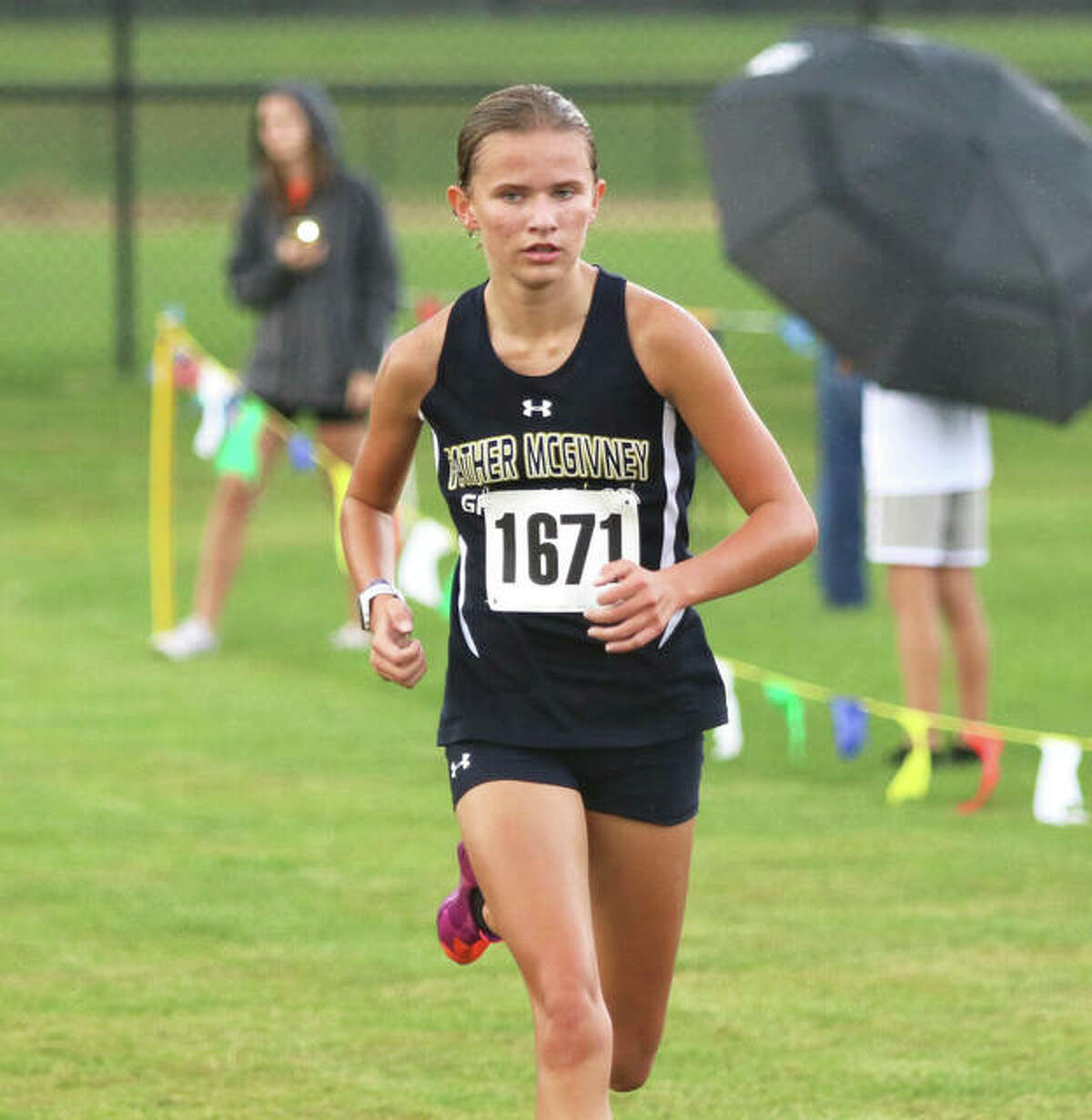 Father McGivney freshman Elena Rybak runs alone on the lead near the finish in her Madison County Meet victory at the Bethalto Sports Complex.