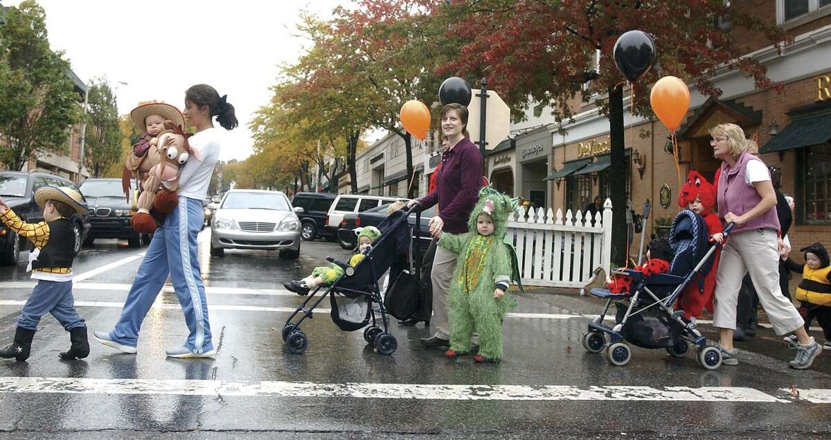 Moms and munchkins cross Greenwich Avenue on a Halloween parade in 2003.