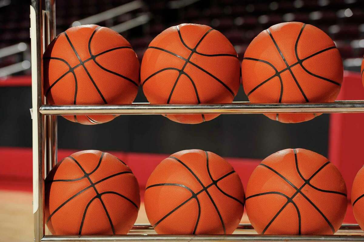 Six basketballs seat in a rack.
