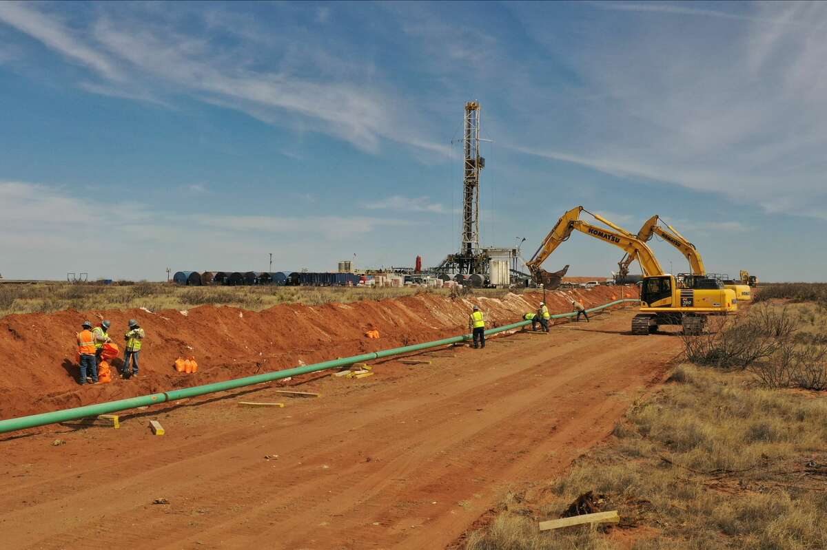 A pipeline is laid out near a drilling rig photographed Feb. 28, 2020 near Loving, New Mexico, in the Permian Basin