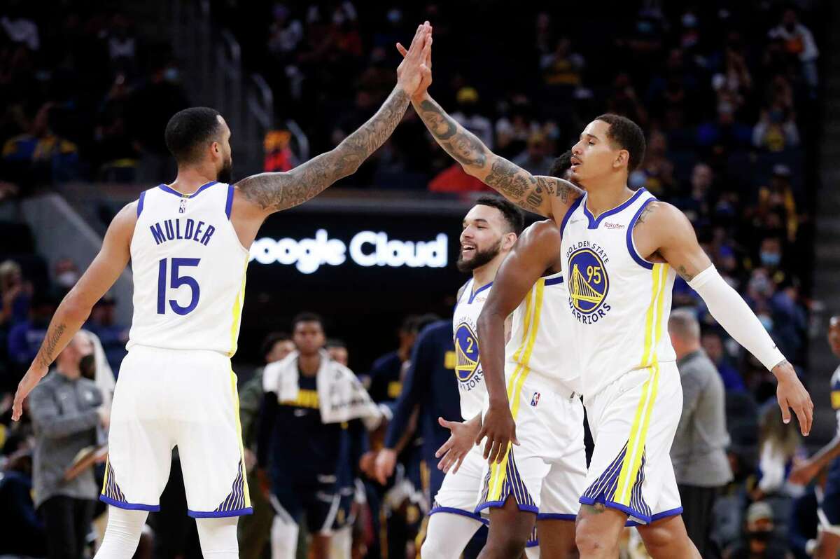Golden State Warriors' Juan Toscano-Anderson high fives Mychal Mulder in 4th quarter of Warriors' 118-116 win over Denver Nuggets during NBA preseason game at Chase Center in San Francisco, Calif., on Wednesday, October 6, 2021.