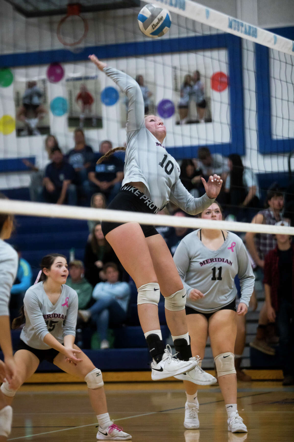 Meridian's Izabelle Dunn spikes the ball during a game against Pinconning Monday, Oct. 18, 2021 at Meridian Early College High School. (Katy Kildee/kkildee@mdn.net)