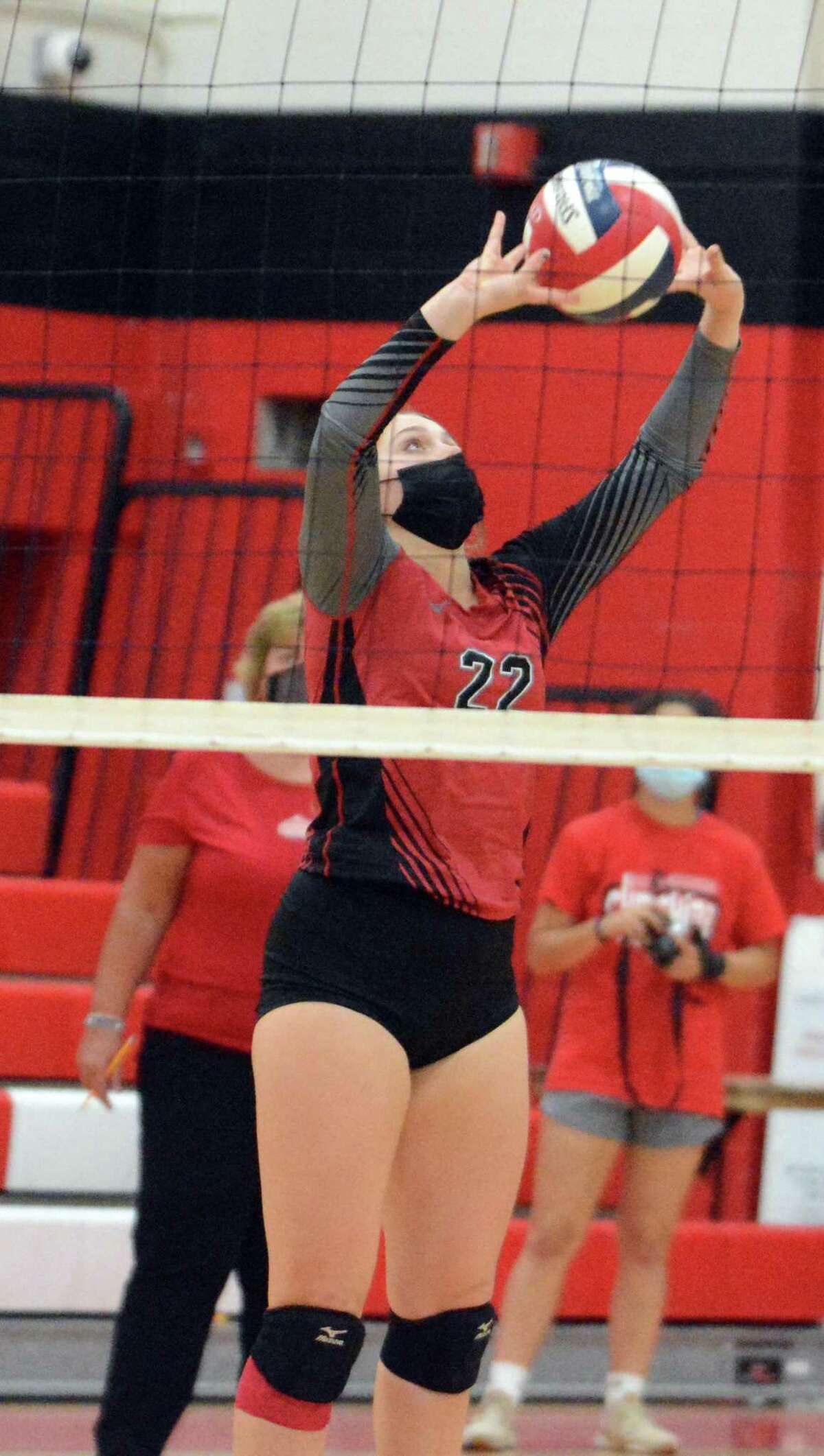 Cheshire's Grace Downing sets the ball for a hitter during a volleyball match Monday night.