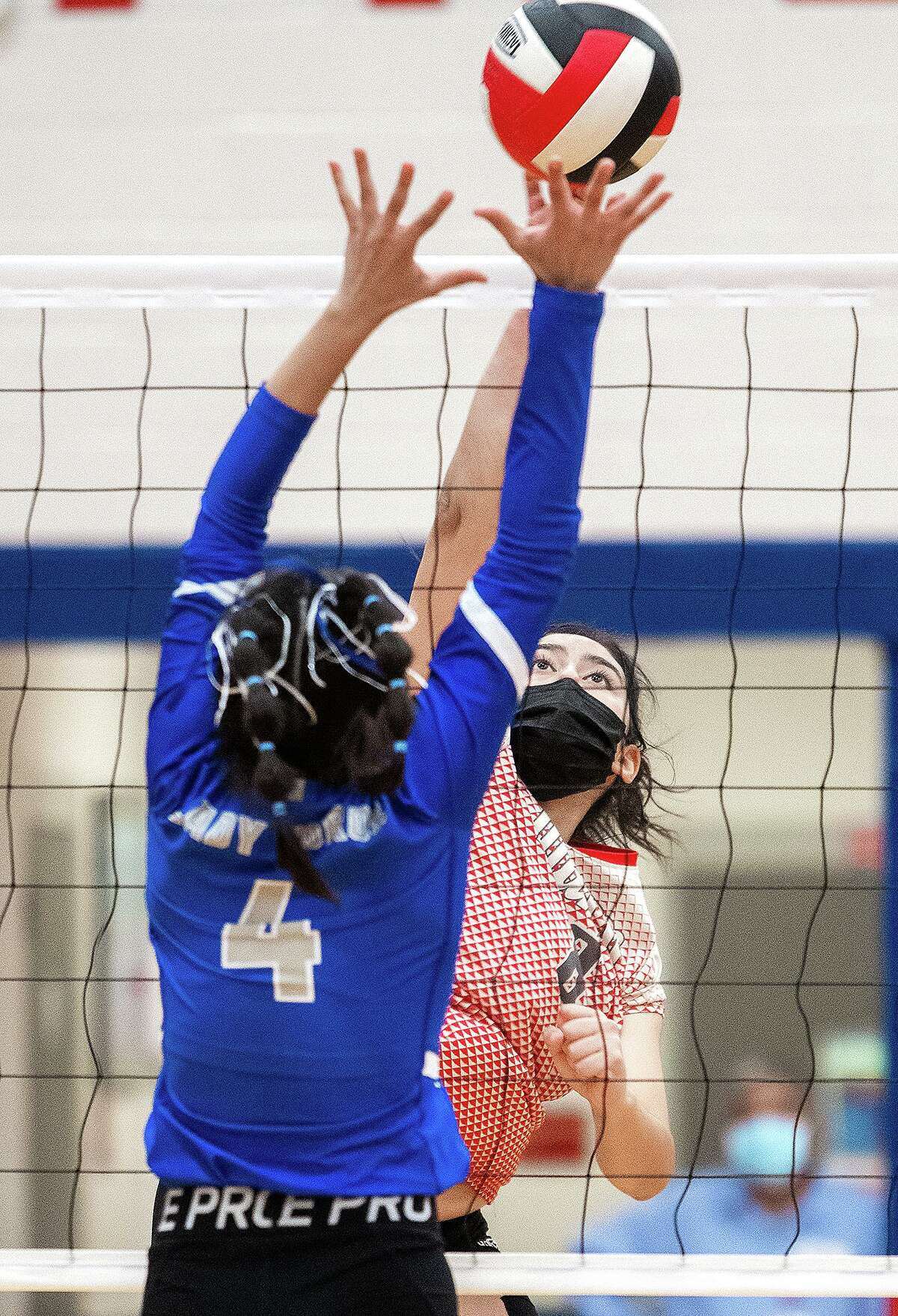Martin High School Ivy Liendo goes up for an attack as Cigarroa High School Julie Benavides attempts to block, Tuesday, Sept. 28, 2021, at Martin High School.