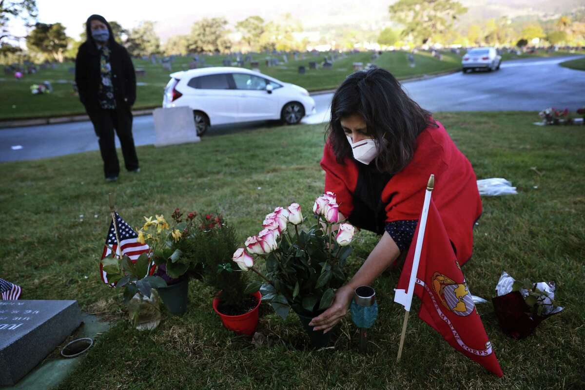 Alexandra Siliezar (right) places flowers at her brothers grave as she talks with Arlene Verino (left), advance planning counselor Cypress Lawn, who Siliezar was meeting to discuss final details of her brother Abraham Siliezar’s headstone during a visit to his gravesite on Wednesday, January 6, 2020 in Colma, Calif. Abraham Siliezar was last seen alive on security footage leaving his home at 250 Kearny Street on August 10, 2020. He was found on September 11, 2020 in a ravine near Land’s End. In October 2020 his remains were identified and his family notified.