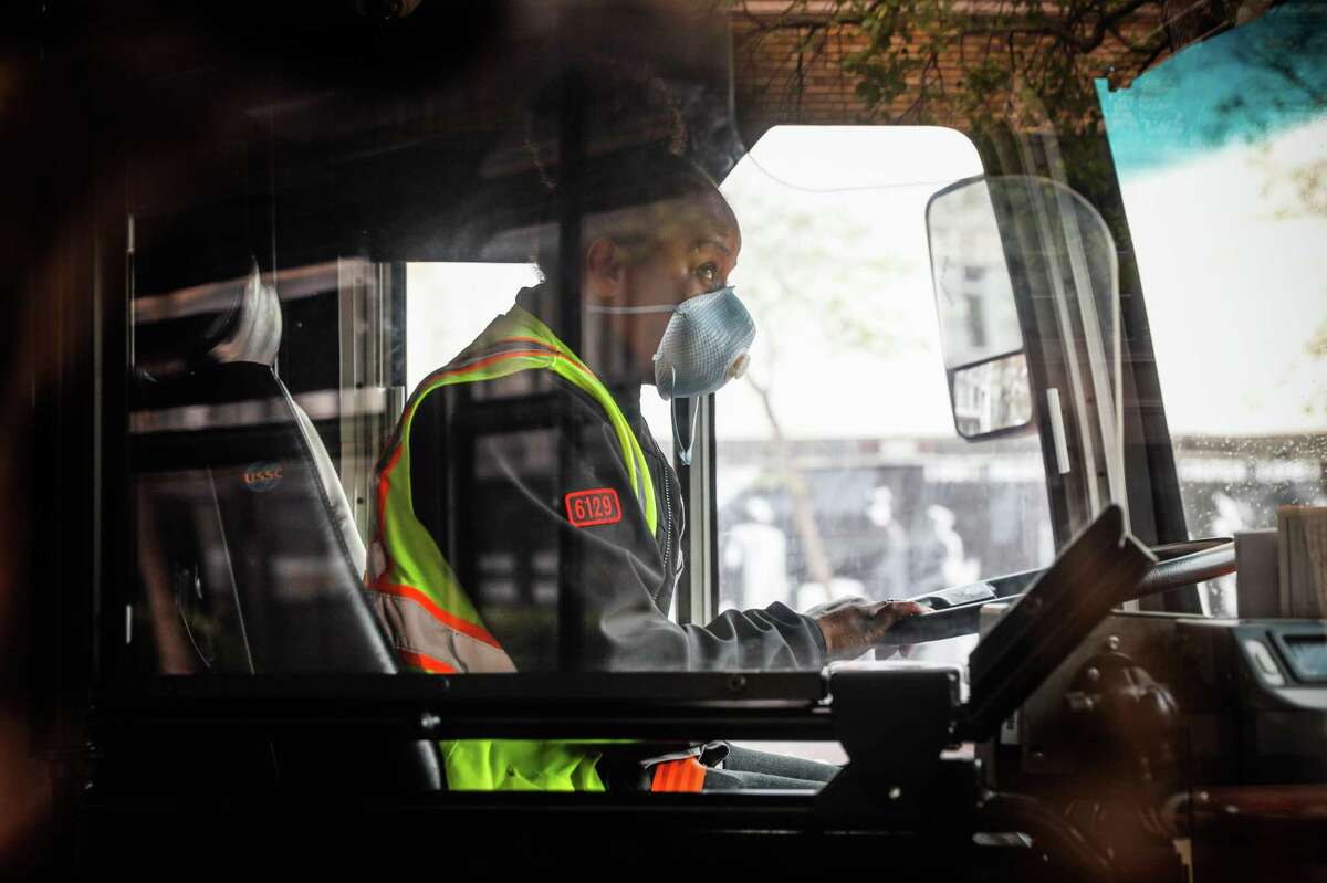 A Muni bus driver wears a mask while driving on Market Street last March. The San Francisco transit agency could lose many of its operators if they don’t comply with the city’s vaccine mandates.