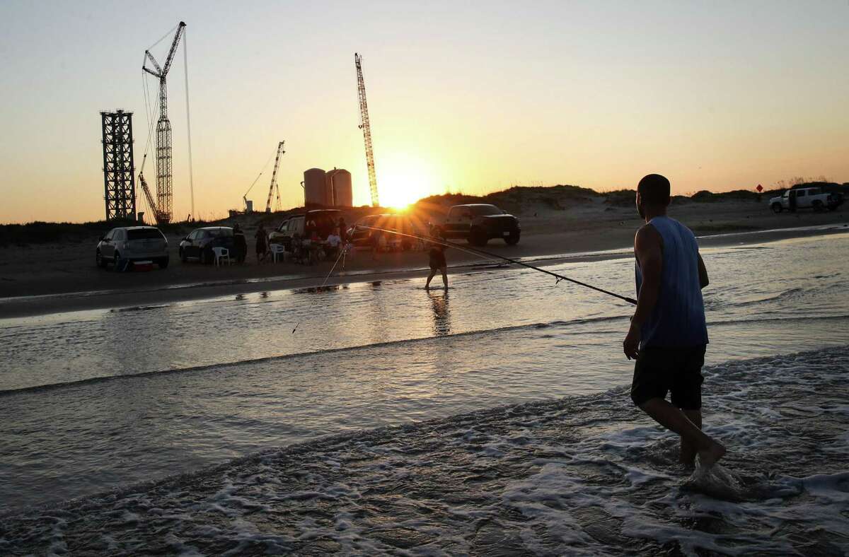Joe Carrizales fishes with family as construction of the SpaceX launch facility continues in the background Monday, June 14, 2021, in Boca Chica.