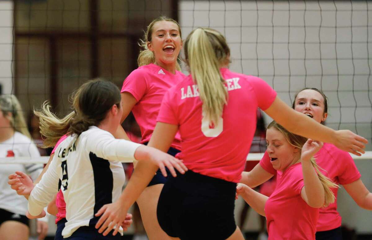Lake Creek’s Lauren Hilty (7) celebrates after an ace by Tyson Menville in the first set of a high school volleyball match at Porter High School, Tuesday, Oct. 19, 2021, in Porter.