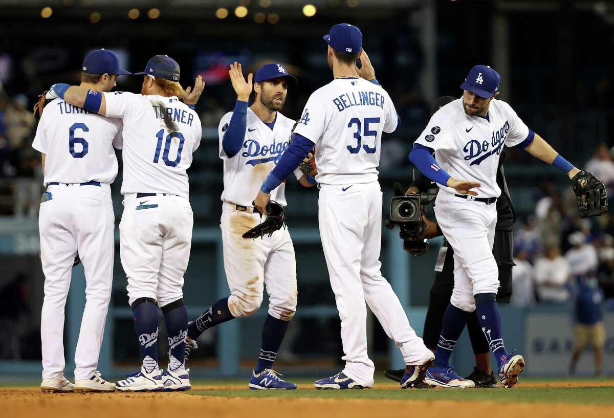 LOS ANGELES, CALIFORNIA - OCTOBER 19: Los Angeles Dodgers players congratulate each other after the Dodgers defeated the Braves 6-5 to win Game 3 of the National League Championship Series against the Atlanta Braves at Dodger Stadium on October 19, 2021 in Los Angeles, California. (Photo by Sean M. Haffey/Getty Images)