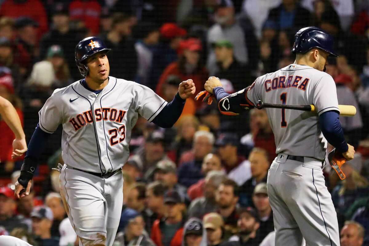 Houston Astros left fielder Michael Brantley (23) celebrates with Houston Astros shortstop Carlos Correa (1) after Brantley was driven home on a single by Houston Astros designated hitter Yordan Alvarez (44) to give the Astros a 7-2 lead during the ninth inning in Game 4 of the American League Championship Series on Tuesday, Oct. 19, 2021, at Fenway Park in Boston.