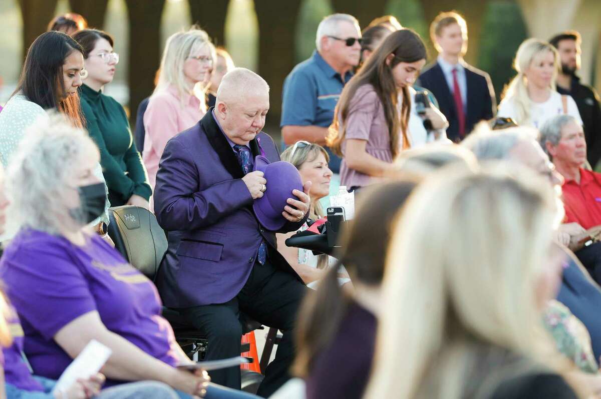 Floy Day, dressed in purple in honor of Domestic Violence Awareness Month, takes in a moment of silence to remember those affected by domestic violence during a small ceremony Oct. 20 at the Montgomery County Veterans War Memorial Park in Conroe.