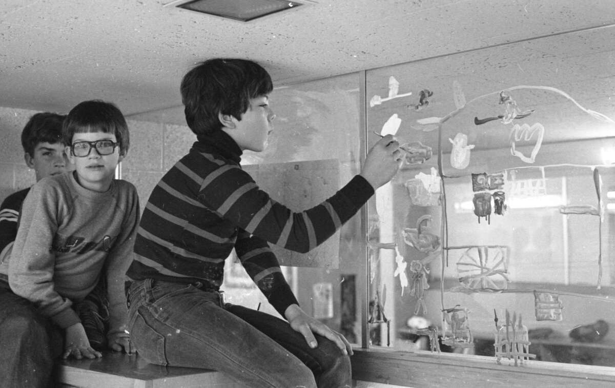 The Manistee Recreation Association's annual window-painting contest for young area residents is in full swing this week as youngsters paint ghoulish Halloween scenes on the display windows of cooperating downtown merchants. The photo was published on Oct. 22, 1981 in the News Advocate. (Manistee County Historical Museum photo)