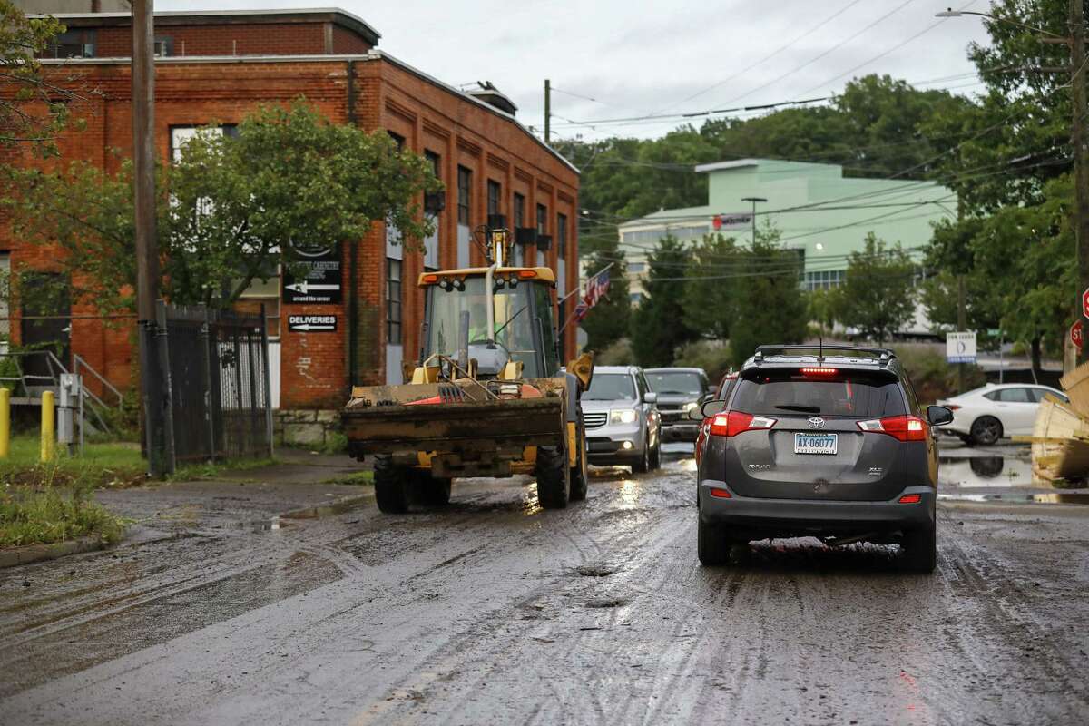 Traffic weaves around abandoned vehicles in South Norwalk following the rains of Tropical Storm Ida.