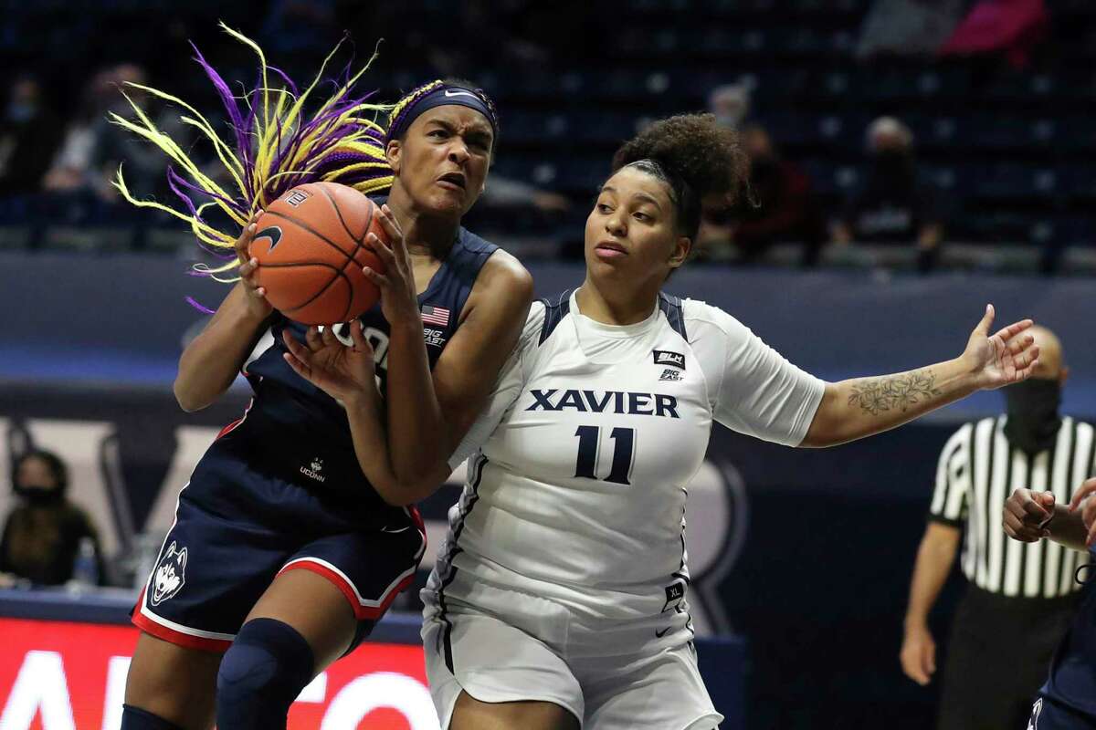 UConn forward Aaliyah Edwards, left, fights for a rebound against Xavier guard Kae Satterfield (11) during the second half of an NCAA college basketball game Saturday, Feb. 20, 2021, in Cincinnati. UConn won 83-32. (AP Photo/Gary Landers)