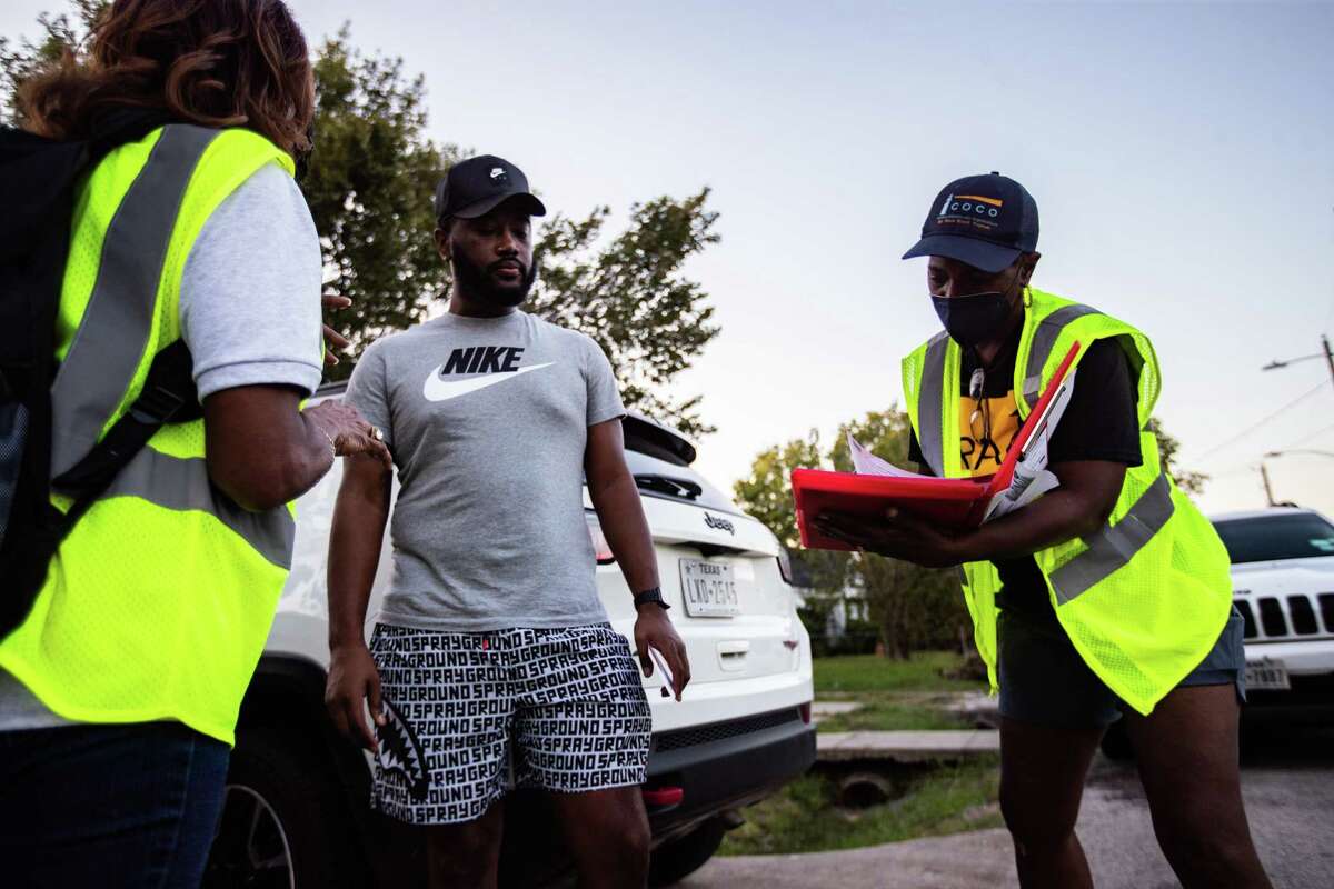 Coalition of Community Organizations block captain Sandra Edwards, right, fills information provided by Xavier Calhoun, 29, about the home of his aunt which might have lead, Thursday, Oct. 7, 2021, in Houston. The home is located at Fifth Ward which is an area that has been identified with homes exposed with lead.