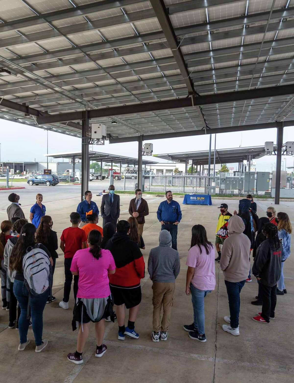 Poe Middle School students stand Wednesday under one of Big Sun Solar's community solar installations. The students were researching how to convert schools to renewable energy for Resource Central’s national competition.