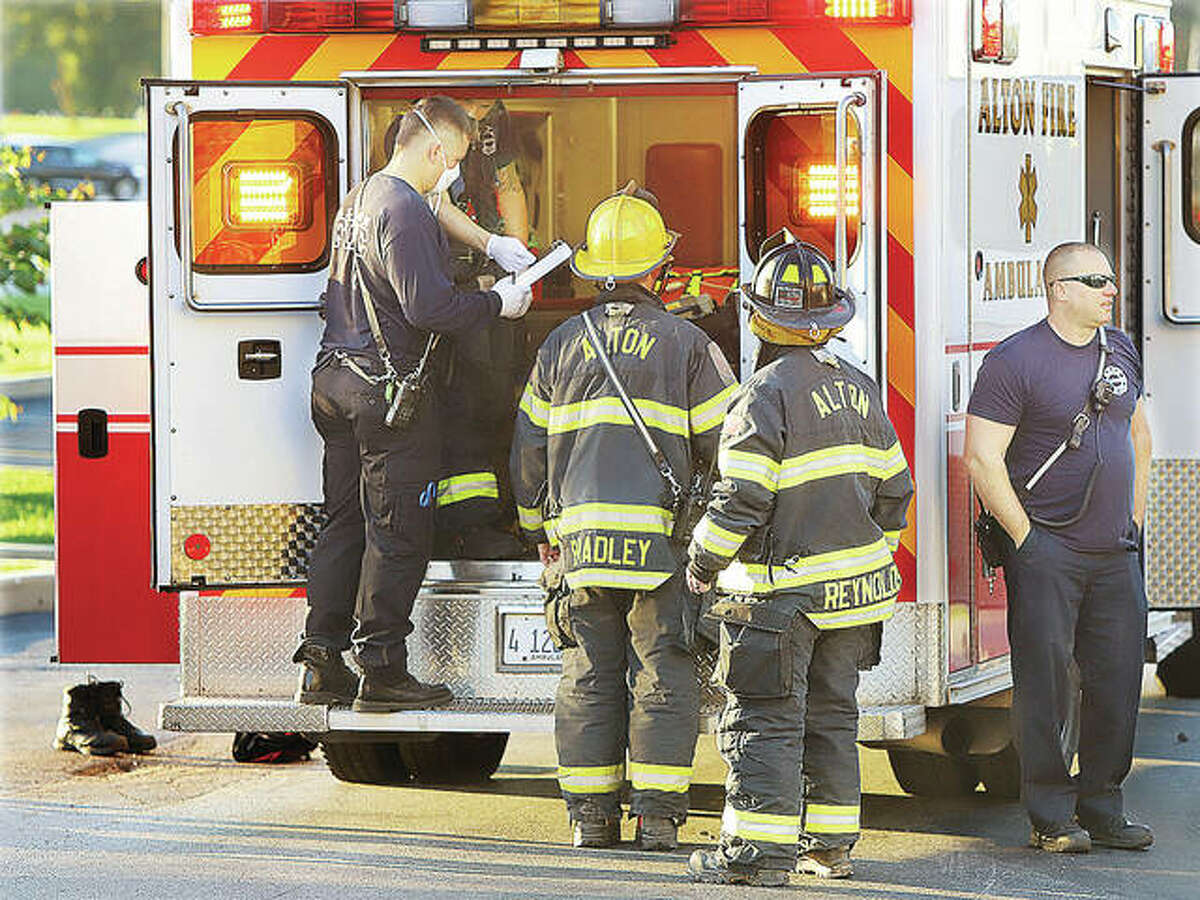 Alton firefighters prepare two women for transport to a hospital Wednesday morning after the women apparently breathed in fumes from a bug bomb that had been set off in a fourth floor room at the Hampton Inn and Suites on the Homer Adams Parkway.