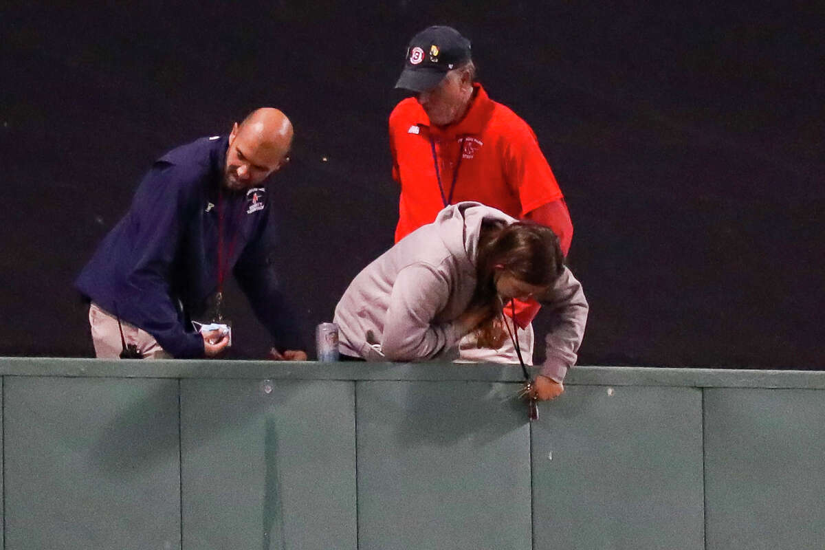 Facilities staff work on something on the center field wall that has attracted the attention of the umpires during the sixth inning in Game 5 of the American League Championship Series on Wednesday, Oct. 20, 2021, in Boston.