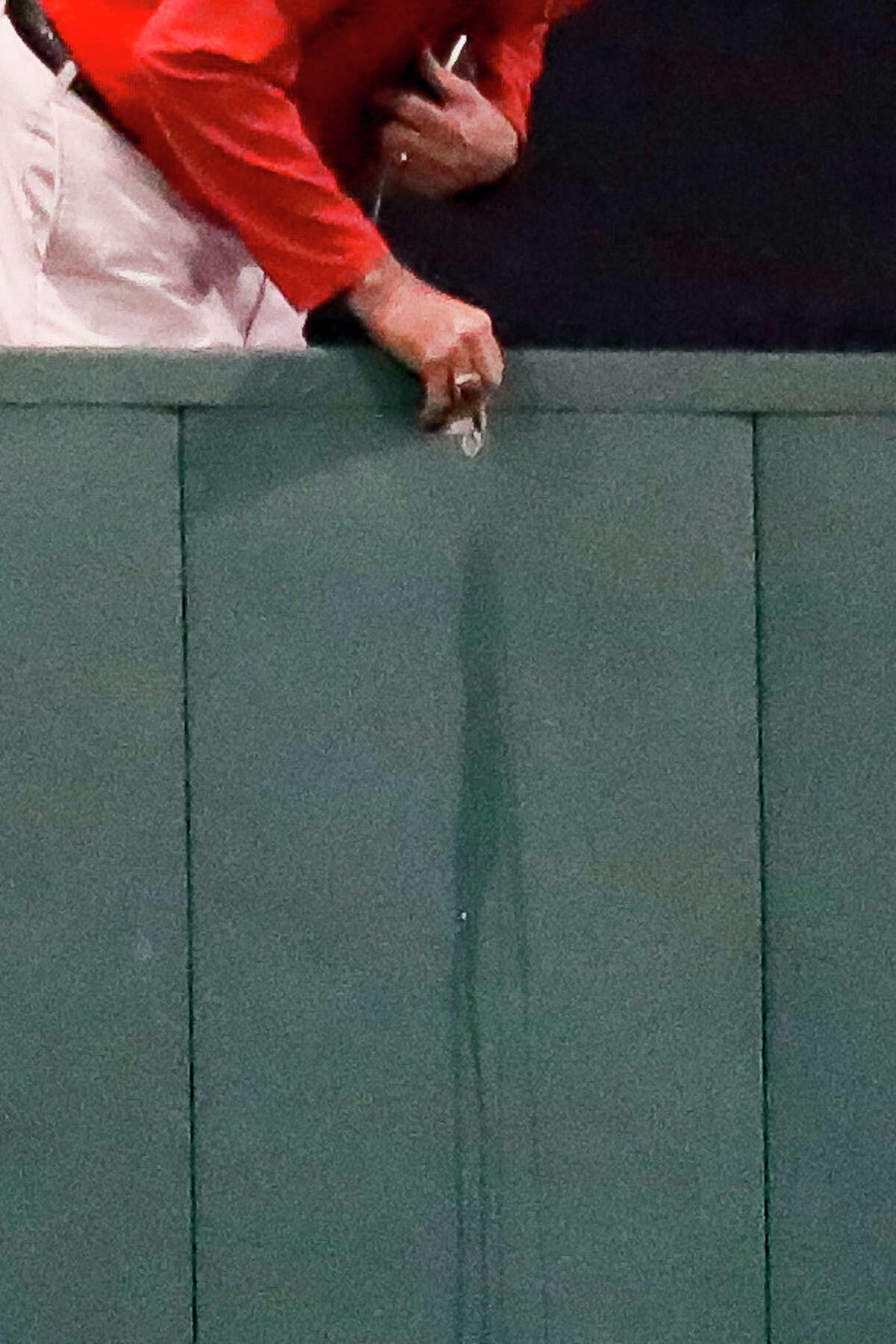 Facilities staff work on something on the center field wall that has attracted the attention of the umpires during the sixth inning in Game 5 of the American League Championship Series on Wednesday, Oct. 20, 2021, in Boston.