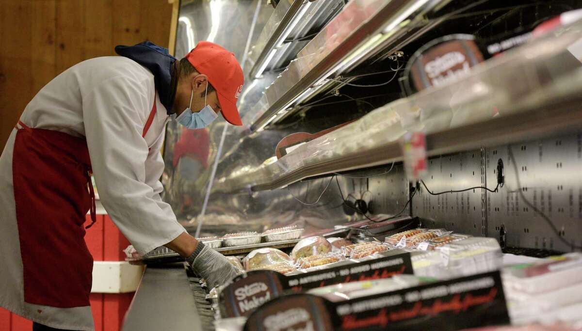 Juan Abames, a meat wrapper at Stew Leonard’s, stocks a cooler. 