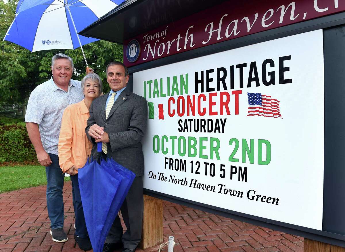 From left to right, Nick Casella, co-chair of the Italian Heritage Concert, Laura Florio Luzzi, chair of the Greater New Haven Italian American Heritage Committee, and North Haven First Selectman Michael Freda on North Haven Green on September 28, 2021 by a sign making the advertisement of the Italian Heritage Concert.