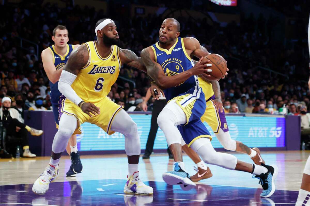 Golden State Warriors forward Andre Iguodala (9) drives against Los Angeles Lakers forward LeBron James (6) during the second half of an NBA basketball game in Los Angeles, Tuesday, Oct. 19, 2021. The Warriors won 121-114. (AP Photo/Ringo H.W. Chiu)