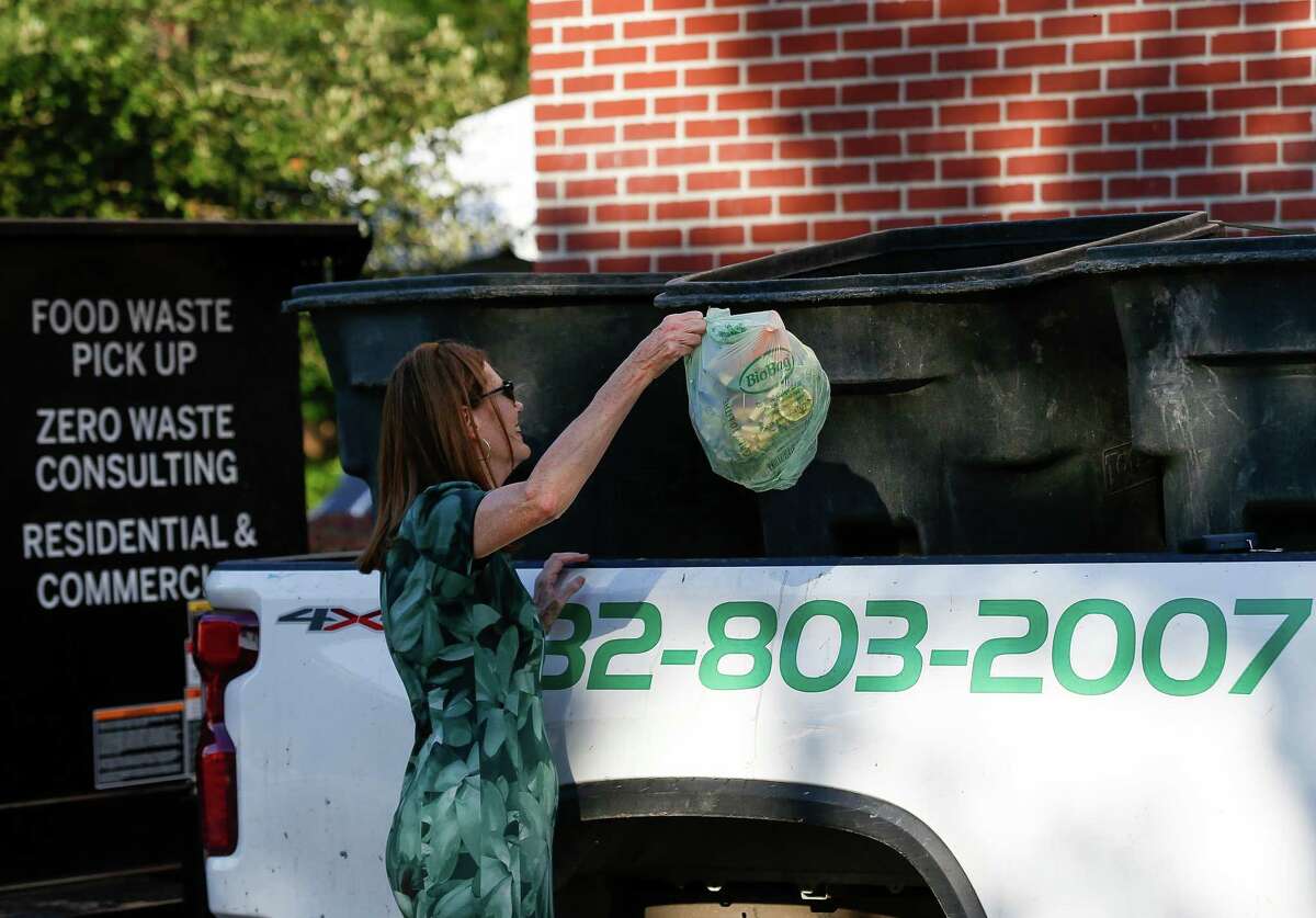 Council member Sallie Alcorn tossed a bag of compostable waste into a collection bin during the first day of the city's composting pilot program at the Historic Heights Fire Station on Wednesday, Oct. 20, 2021, in Houston. The program is aimed at educating residents about the benefits of composting and preventing food waste from reaching landfills. During the six-week period residents will have once-a-week composting drop-off locations available at The Historic Heights Fire Station, Houston Botanic Garden, and Kashmere Multi-Service Center.