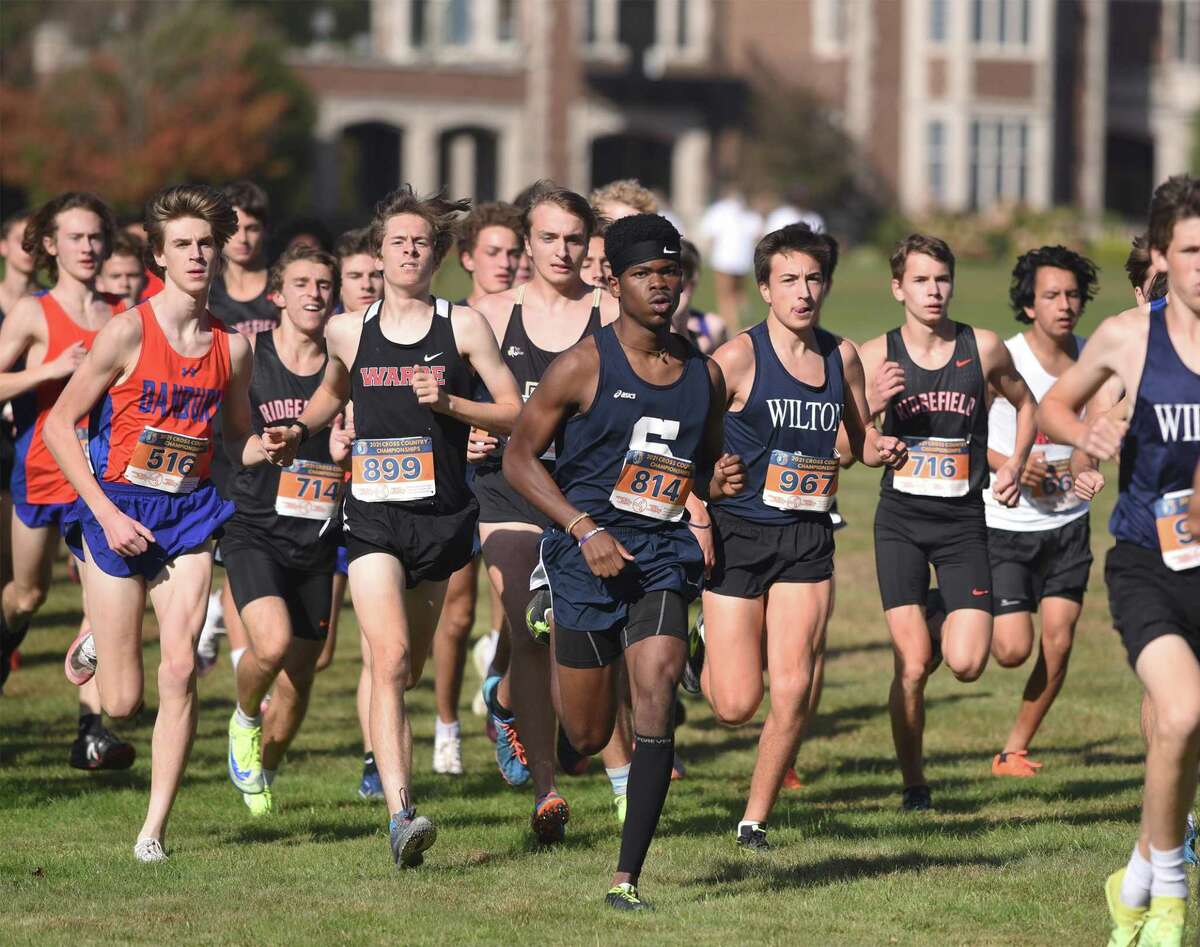 Runners race in front of Waveny House during the FCIAC boys cross country championship in New Canaan's Waveny Park on Wednesday, Oct. 20, 2021.