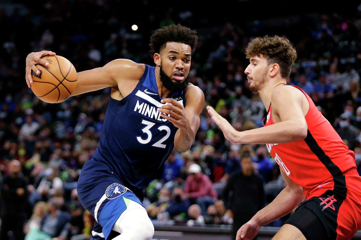 Minnesota Timberwolves center Karl-Anthony Towns (32) drives on Houston Rockets center Alperen Sengun (28) during the first half of an NBA basketball game Wednesday, Oct. 20, 2021, in Minneapolis. (AP Photo/Andy Clayton-King)