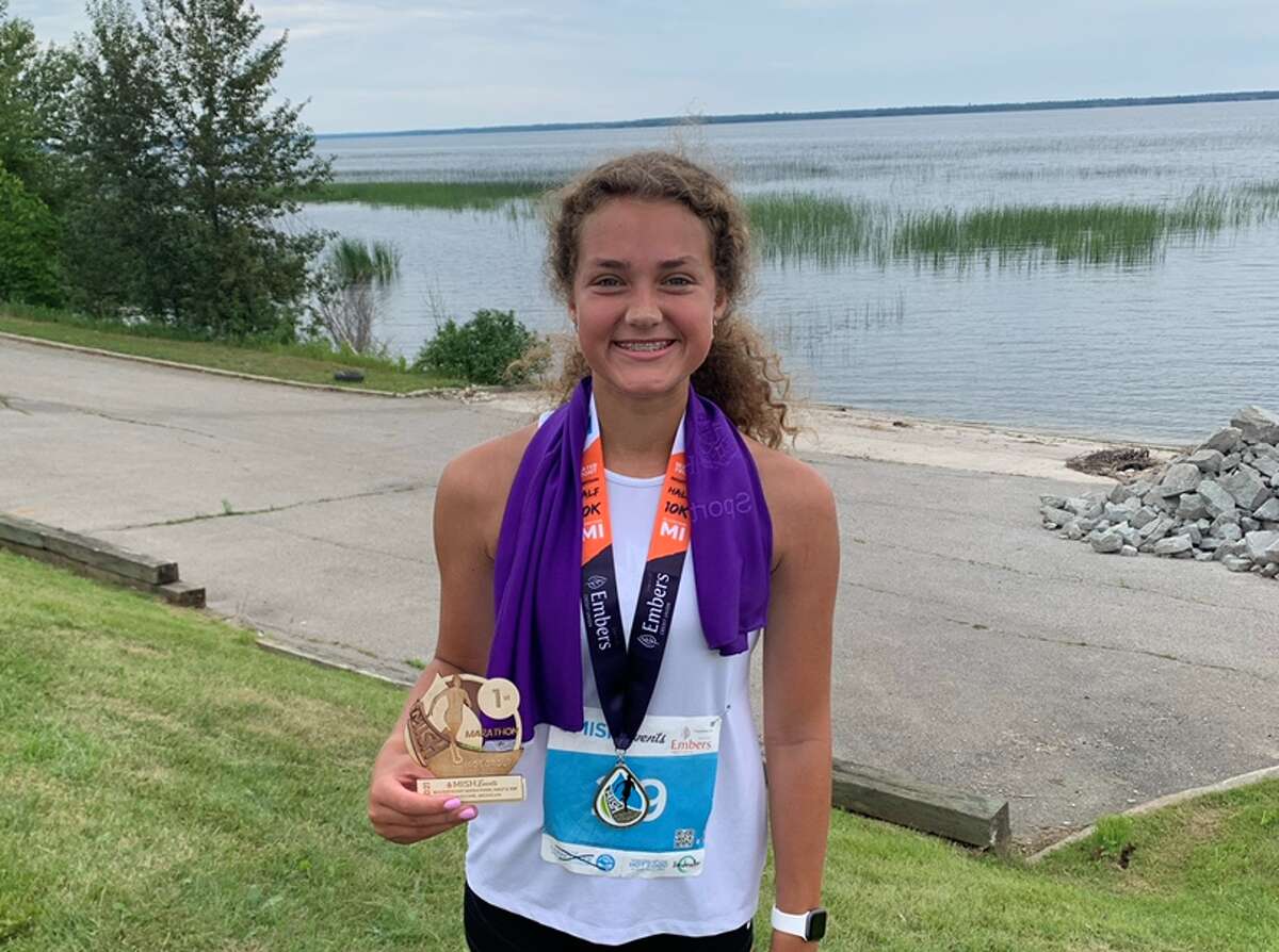 Coleman's Kaylee Aultman poses on the shore of Lake Superior after completing the MISH Waterfront Marathon in Gladstone this past summer.