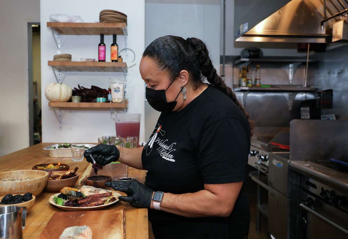 Chef Crystal Wahpepah of Wahpepah’s Kitchen prepares a salmon plate at her Oakland restaurant, which is gearing up to open Oct. 30.