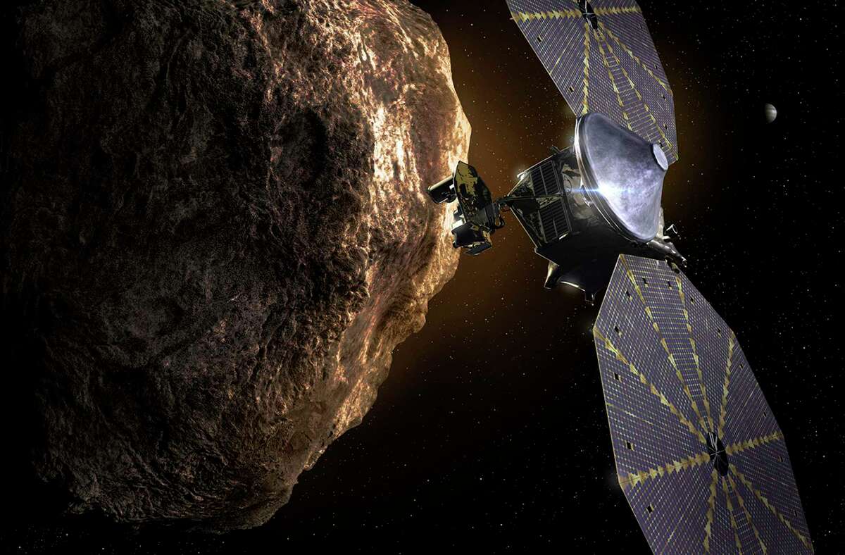 This image provided by the Southwest Research Institute depicts the Lucy spacecraft approaching an asteroid. It will be first space mission to explore a diverse population of small bodies known as the Jupiter Trojan asteroids.