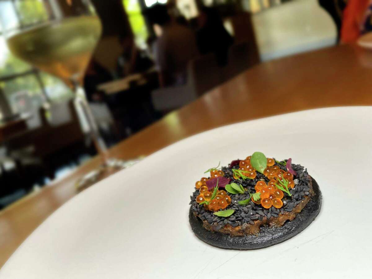 Tichinda is a dish from the Oaxaca menu that combines mussels, dried shrimp and chile paste, black sesame seeds and trout roe on a squid ink masa cake at Mixtli, a progressive Mexican restaurant that moved from a boxcar near Olmos Park to a much larger space in Southtown this year.