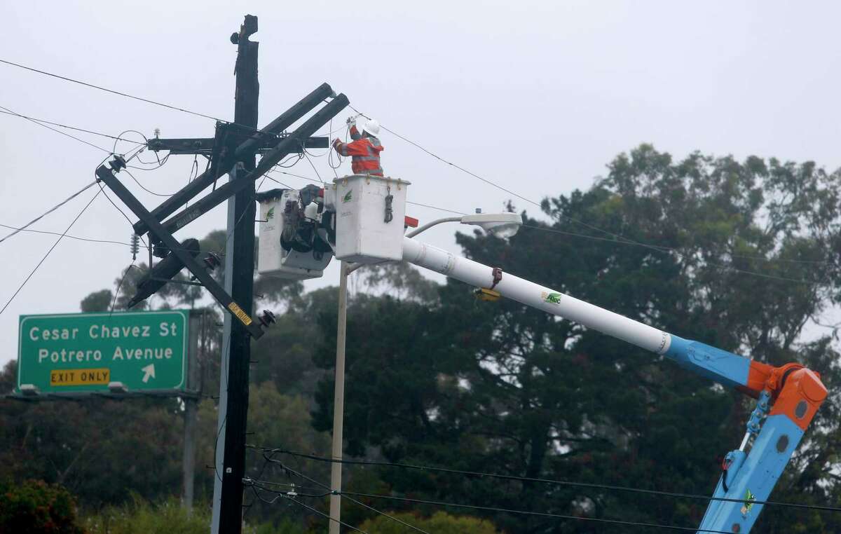 A PG&E crew repairs a broken power pole on Bayshore Boulevard during a 2016 rainstorm in San Francisco.