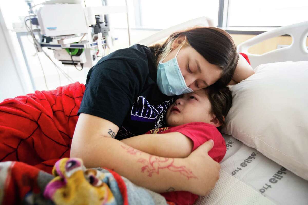 Gia Gonzalez, 19, embraces her son Isaiah Gonzalez, 3, while they rest at the Texas Children’s Hospital intensive care unit, Friday, Oct. 15, 2021, in Houston. Isaiah has been diagnosed with multisystem inflammatory syndrome.