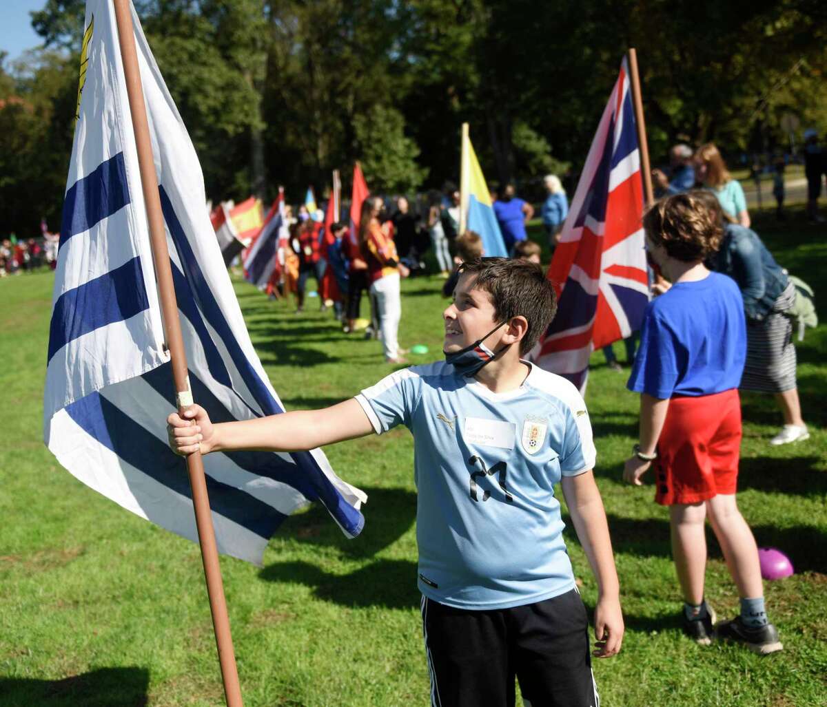 Fourth-grader Tiago Da Silva holds the Uruguay flag during the United Nations Day Celebration "Parade of Nations" at Julian Curtiss School in Greenwich, Conn. Thursday, Oct. 21, 2021. Students representing 60 countries and speaking 30 different languages marched in the parade, waving flags and wearing clothing to represent their country's heritage.