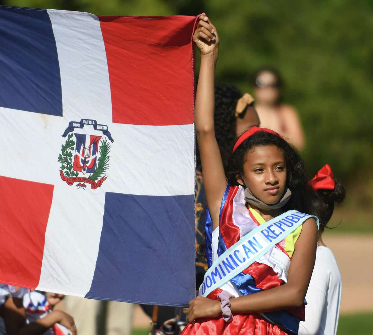 Fourth-grader Mariela Perez Rosario holds the Dominican flag during the United Nations Day Celebration "Parade of Nations" at Julian Curtiss School in Greenwich, Conn. Thursday, Oct. 21, 2021. Students representing 60 countries and speaking 30 different languages marched in the parade, waving flags and wearing clothing to represent their country's heritage.