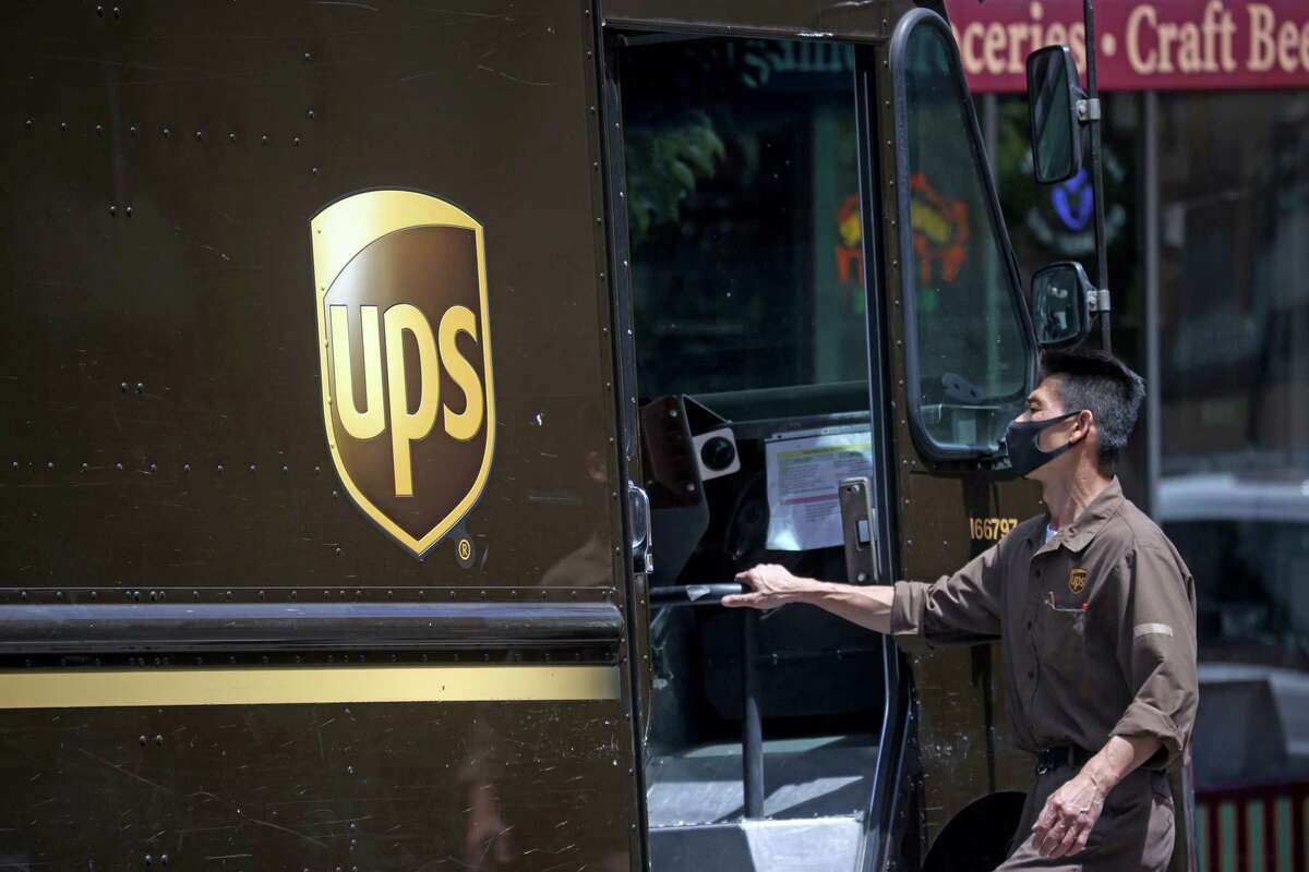 A United Parcel Service (UPS) driver gets into his truck while on his delivery route in San Francisco, California.