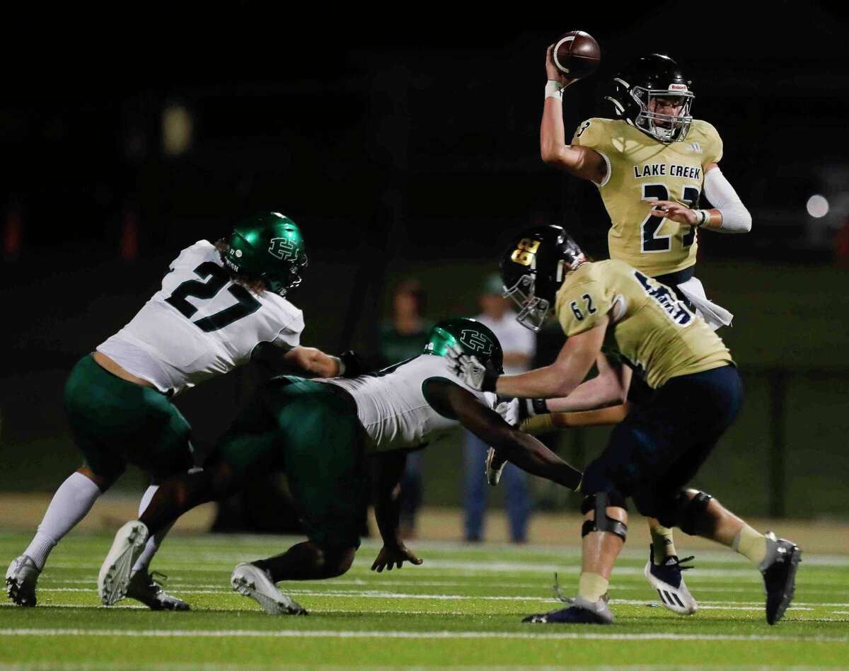 Lake Creek quarterback Parker Smith (23) throws under pressure during the first quarter of a District 10-5A (Div. II) high school football game at MISD Stadium, Thursday, Oct. 21, 2021, in Montgomery.