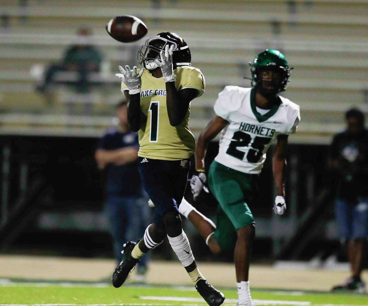 Lake Creek wide receiver Madison Hausler (1) catches a 34-yard touchdown pass during the first quarter of a District 10-5A (Div. II) high school football game at MISD Stadium, Thursday, Oct. 21, 2021, in Montgomery.