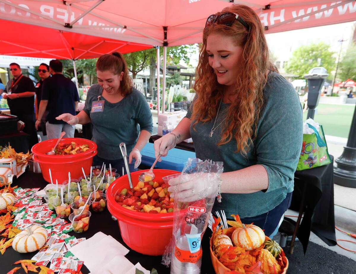 Danielle Steiner, right, and Roxann Johnson prepare fruit cups during the annual HEB Wine Walk, part of Wine and Food Week, at Market Street, Thursday, Oct. 21, 2021, in The Woodlands.